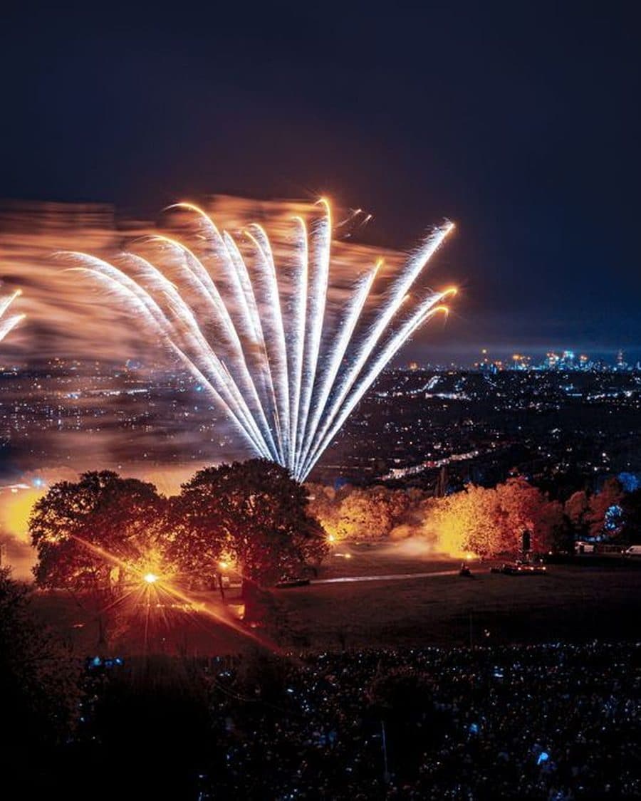 Fireworks bursting over the crowd on the Alexandra Palace slope with the London skyline behind - the official Universe listing photo