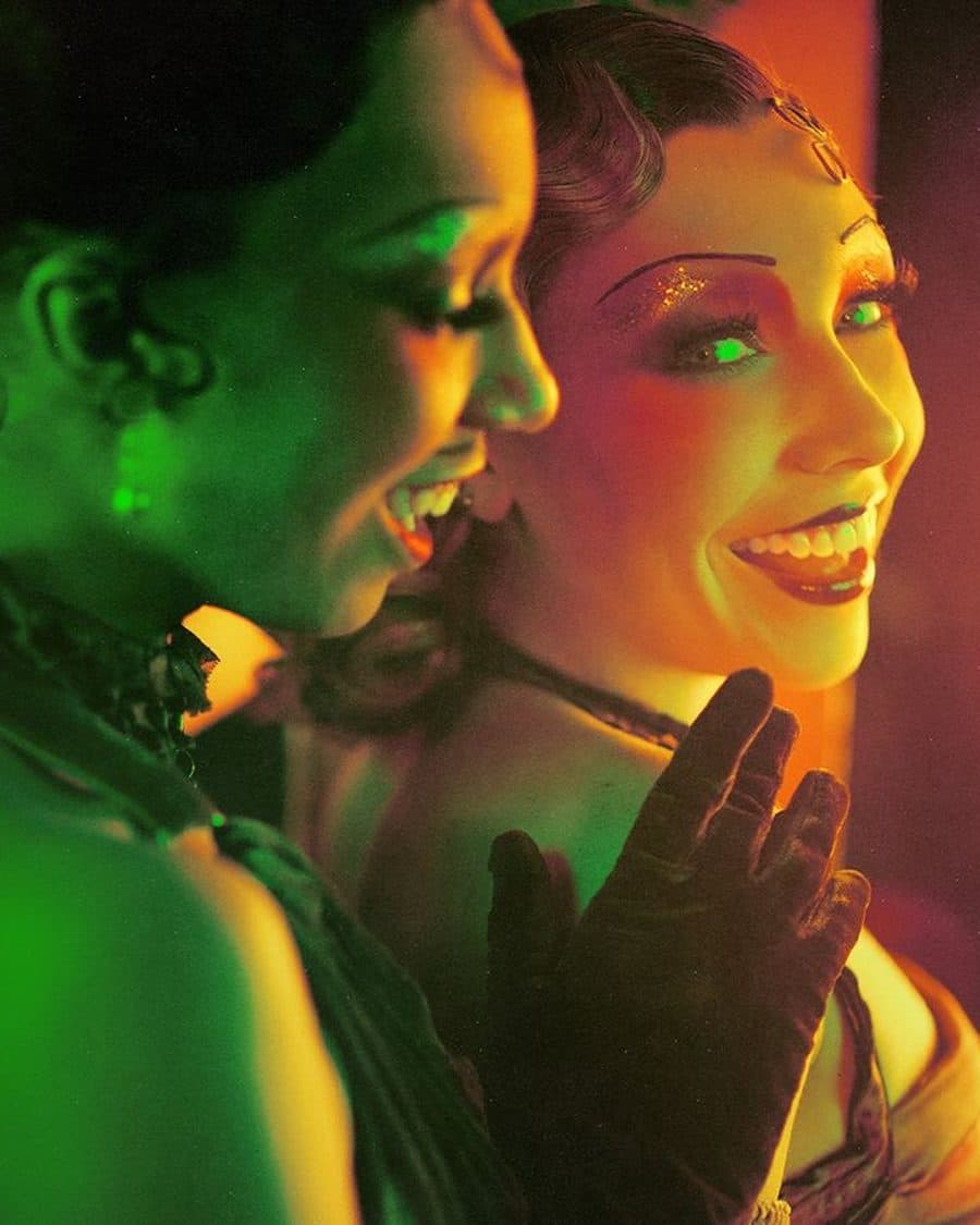 Two Kit Kat Club performers in green and amber stage light with the gold CABARET title and five-star quote - the official production key art