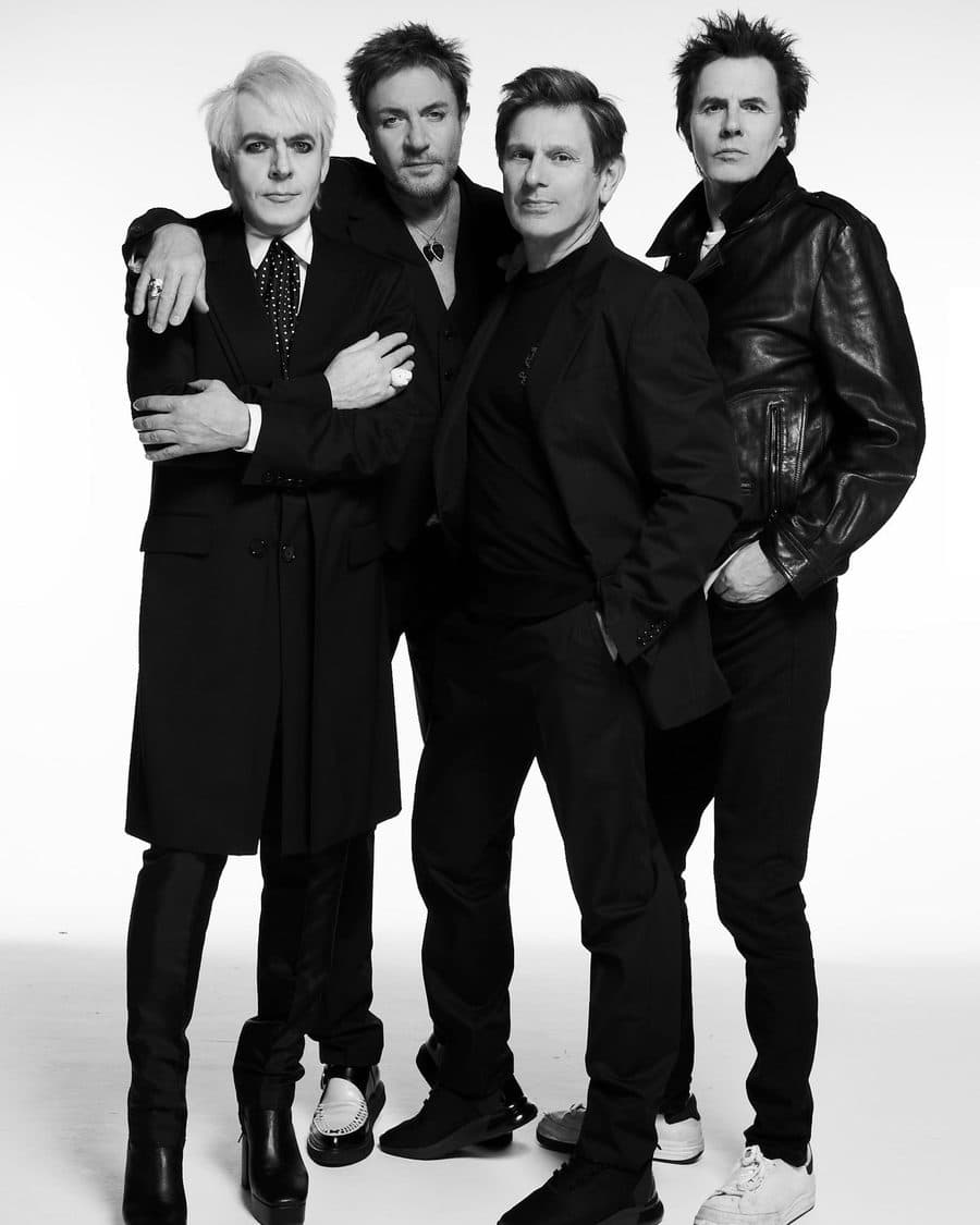 Duran Duran's four members in black outfits in a black-and-white studio portrait - the official 2026 tour image