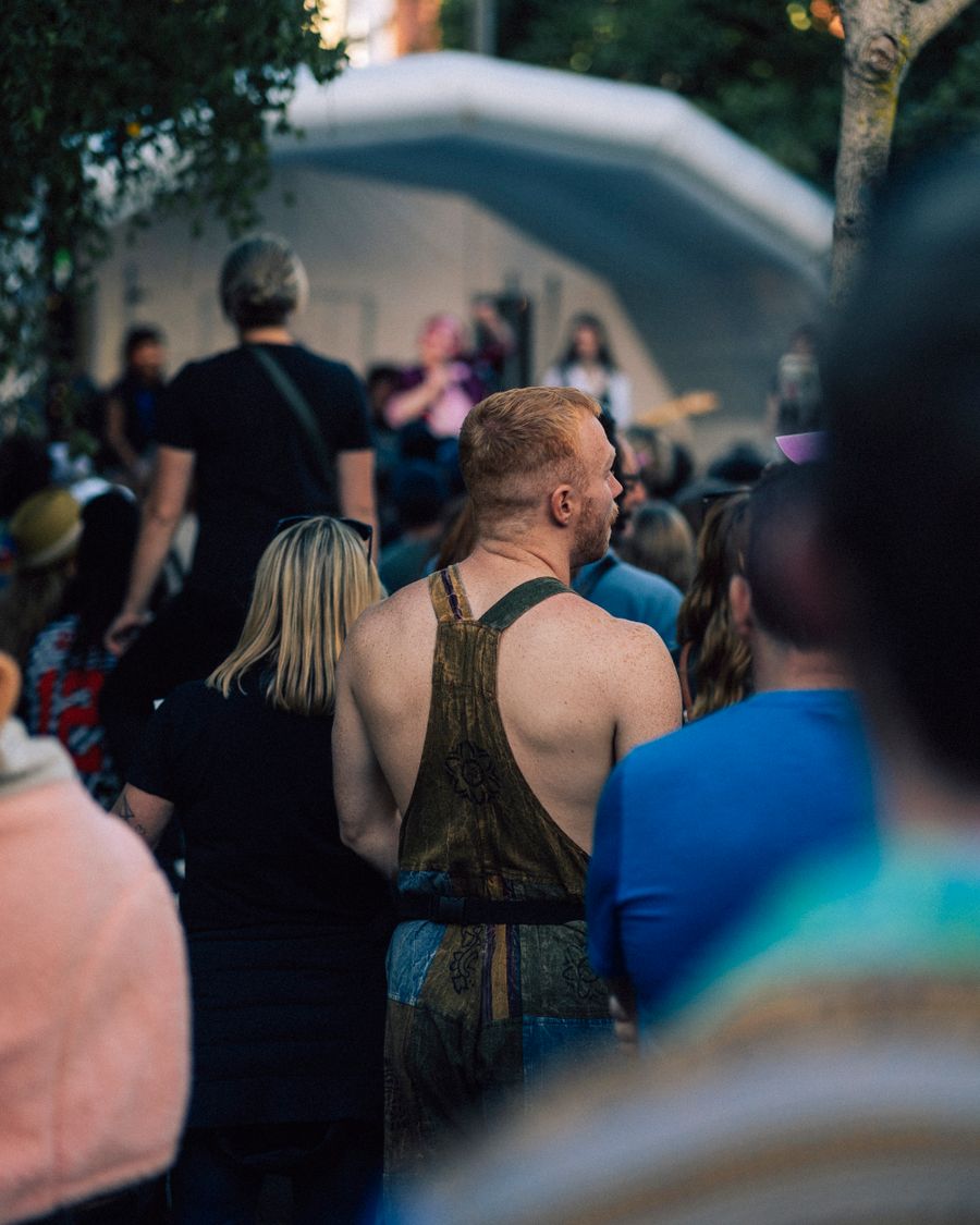 Festival-goers in a park crowd on a summer afternoon