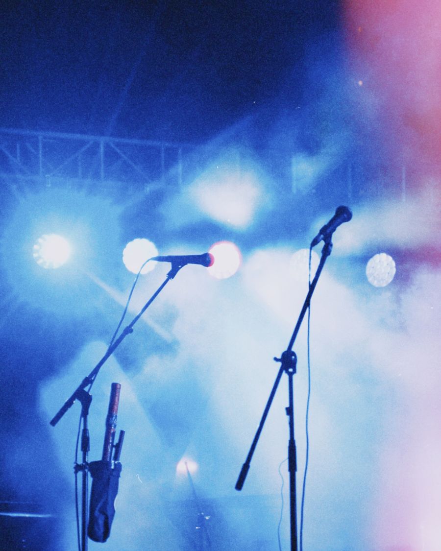 Two microphones on a stage washed in blue light