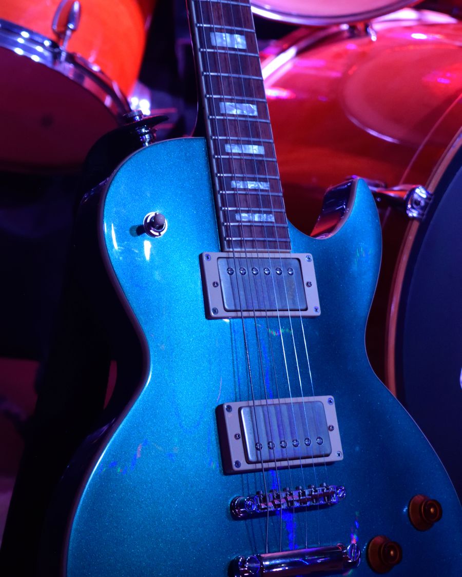 Electric guitar close-up under blue stage lighting