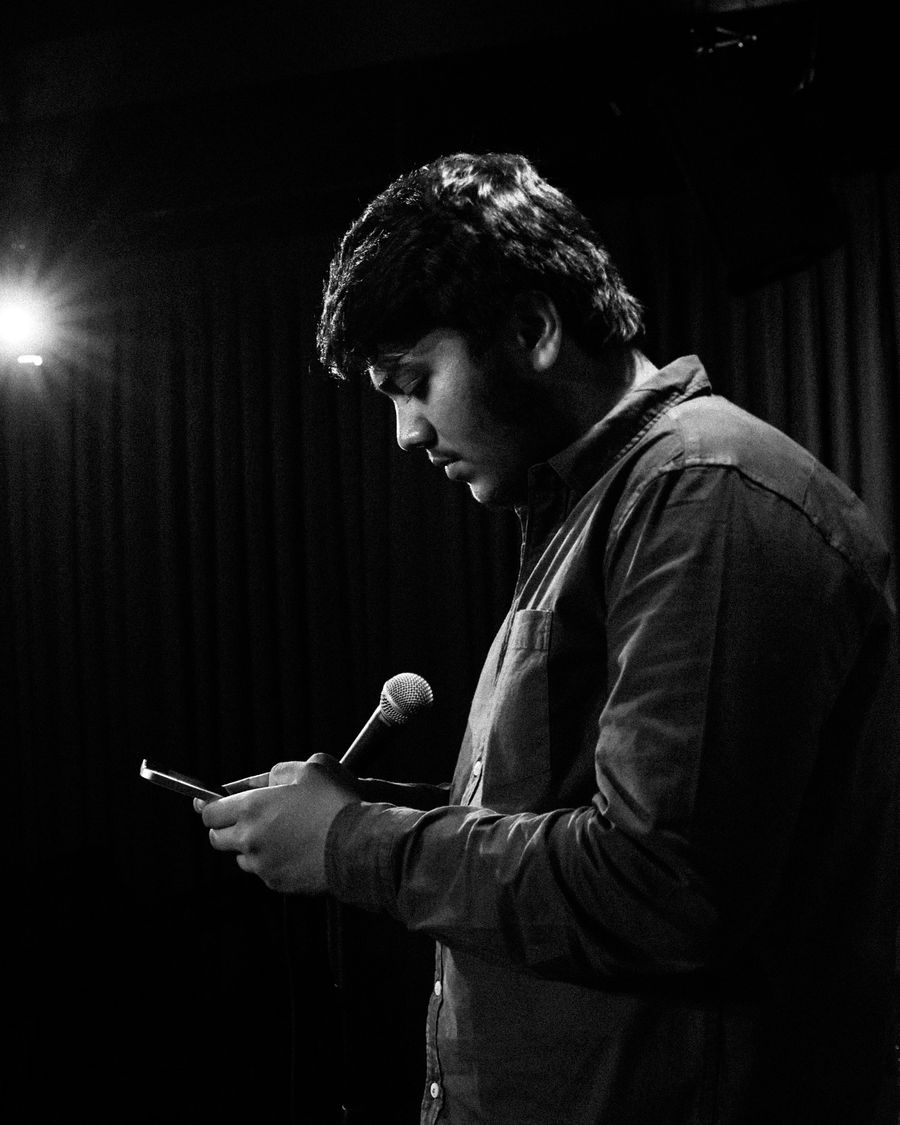 Performer at a microphone in a single spotlight