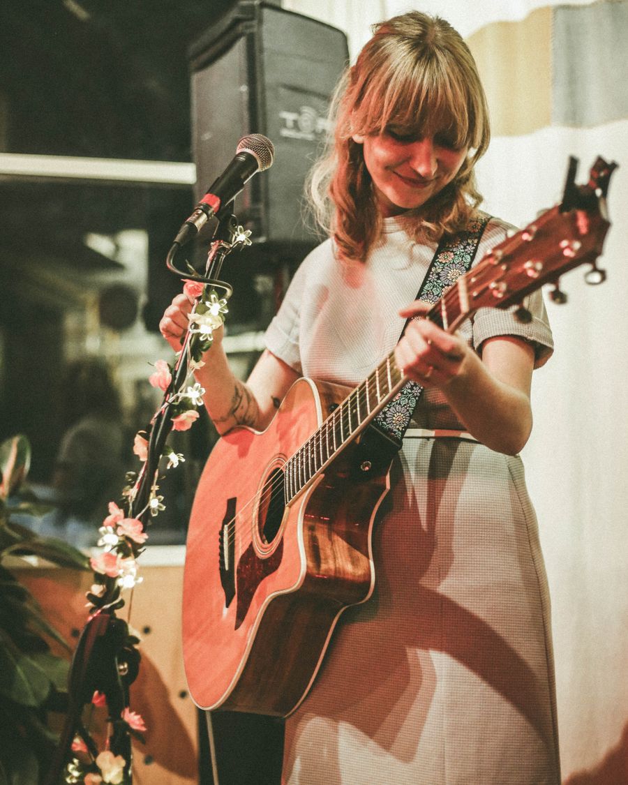 Musician playing acoustic guitar in warm stage light