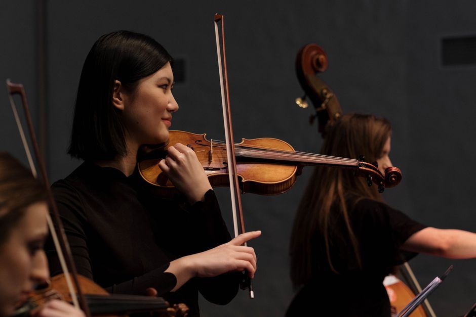 A violinist performing with a string ensemble