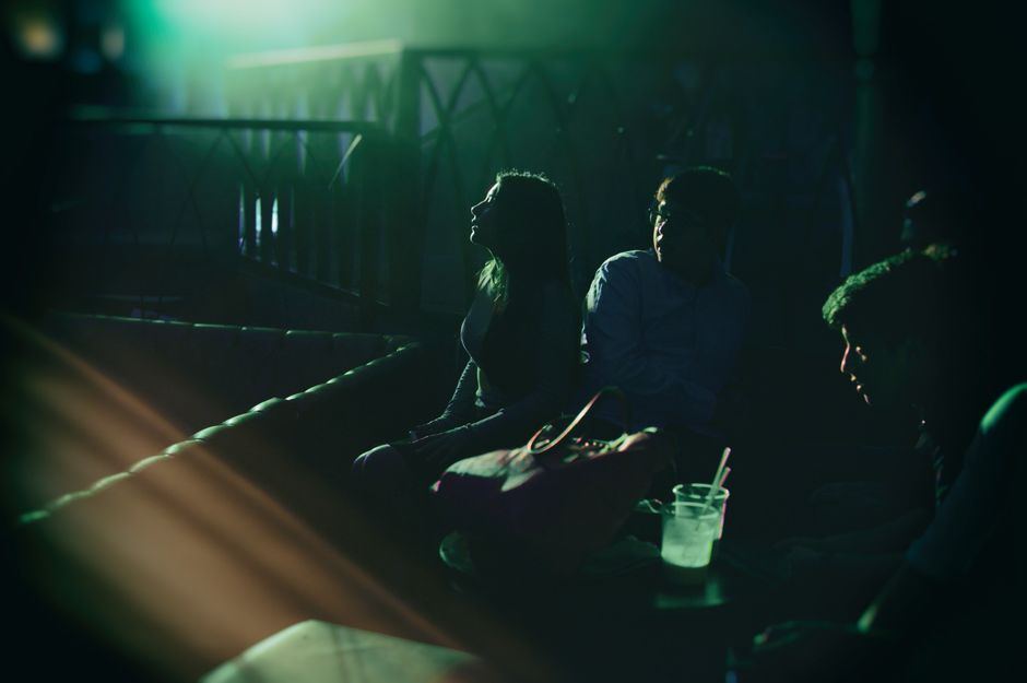 A dimly lit comedy club audience watching a show