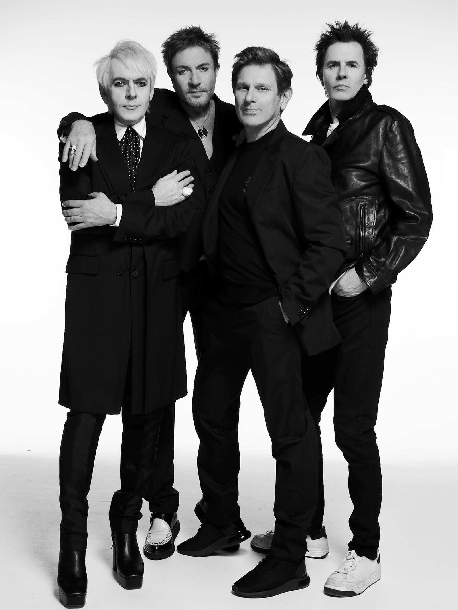 Duran Duran's four members in black outfits in a black-and-white studio portrait - the official 2026 tour image