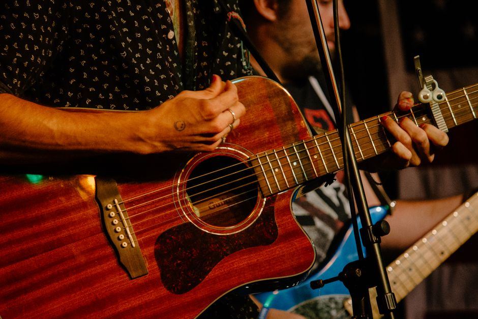 Close-up of hands playing acoustic guitar - folk performance