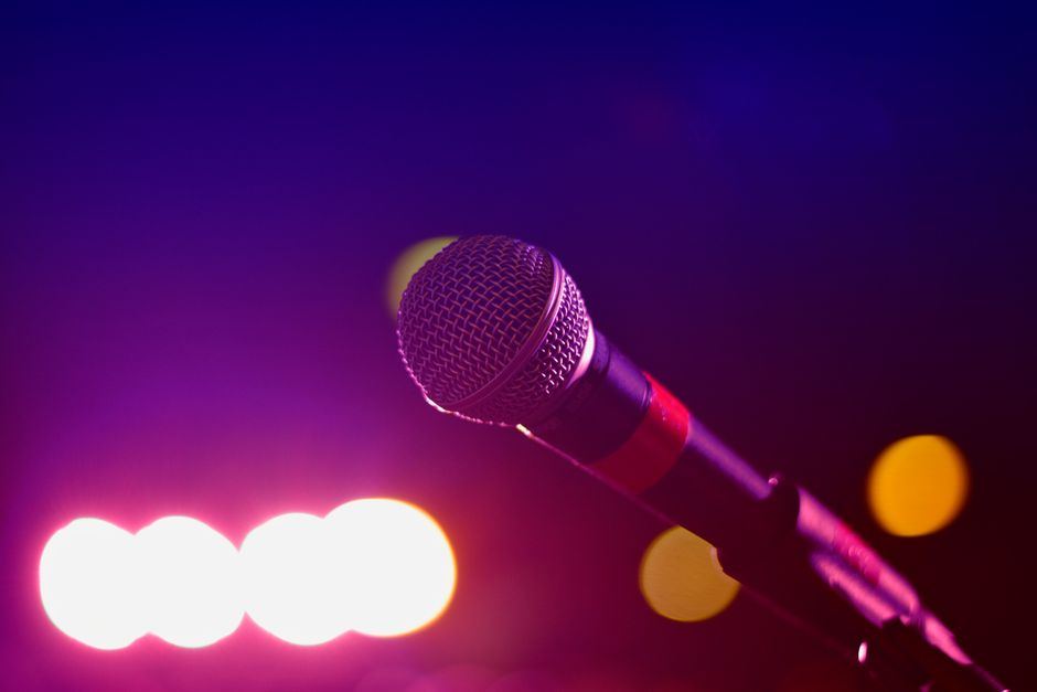 A microphone lit by pink and purple stage lighting
