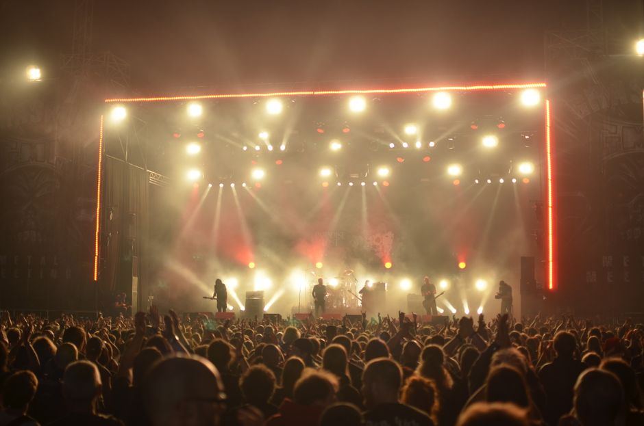 A festival crowd facing a large outdoor stage