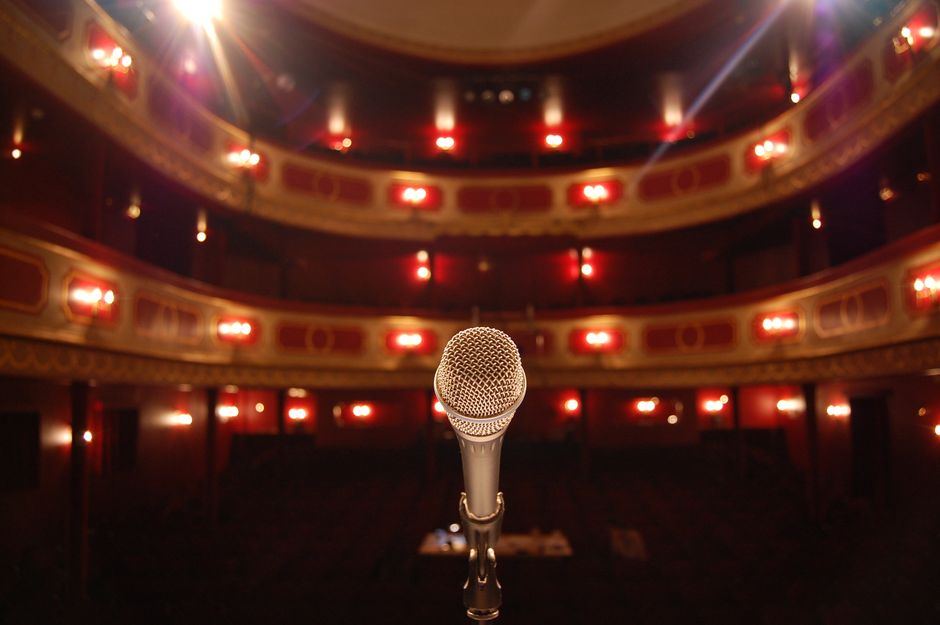 An ornate red theatre interior with a single microphone on stage - opera staging