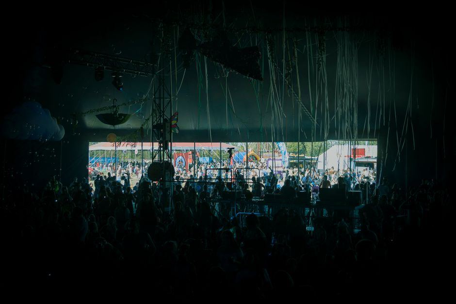 A dark outdoor festival stage between trees