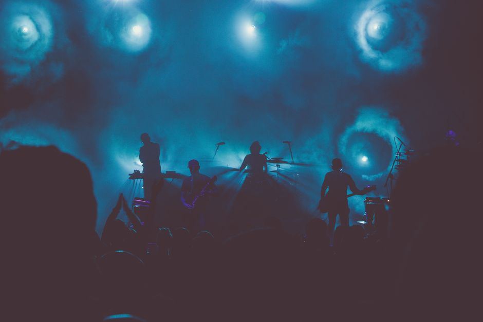 A concert crowd lit by blue stage lighting