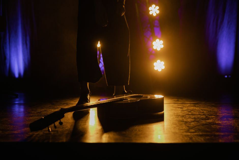 A dramatically lit theatrical stage with candlelight